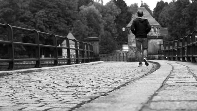 Black and white: man walks along the medieval dam in Liberec (Czech Republic)