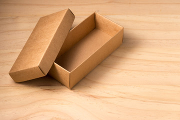 Opened cardboard box on wooden background