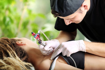 Obraz na płótnie Canvas Tattooist makes tattoo, close up