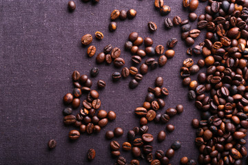 Roasted coffee beans on grey textile background