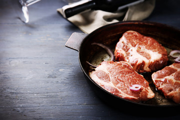 Marbled beef steak and wine bottle on wooden background