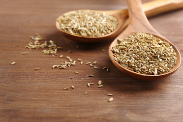 Two wooden spoons with cumin on the table, close-up