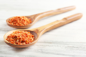 Two wooden spoons with spice on the table, close-up