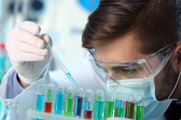 Man in laboratory checking test tubes