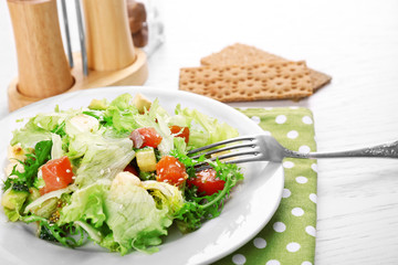 Tasty salmon salad on light wooden background