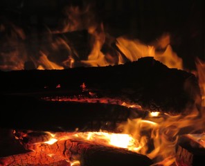 Detail of burning logs, fire, and flames in fireplace or campfire
