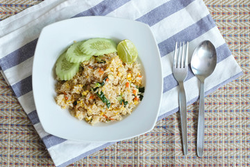 Pork fried rice serving with lime and cucumber