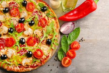 Delicious tasty pizza with ingredients on wooden table