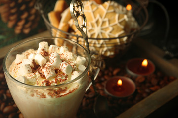 Cup of hot cacao with marshmallow and cookies on coffee beans