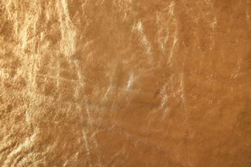 Golden leather texture with crumpled uneven surface