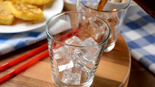 versare la tradizionale bevanda analcolica nel bicchiere di vetro