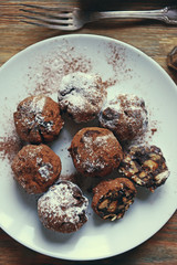 Chocolate balls on a plate on wooden background
