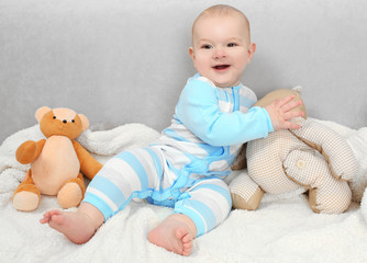 Adorable baby with teddy bears on sofa in the room, close up