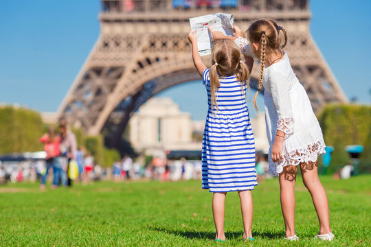 Adorable little girls with map of Paris background the Eiffel tower