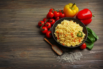 Dish of vegetarian rice on wooden background