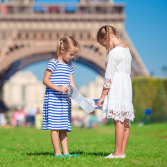 Adorable little girls with map of Paris background the Eiffel tower