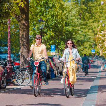 Young happy caucasian couple on bikes in Amsterdam
