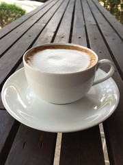 cup of coffee with milk on wood table