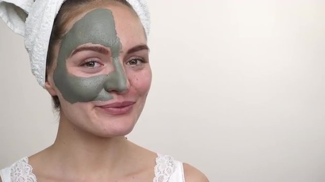 Woman with green clay mud mask on face 4K