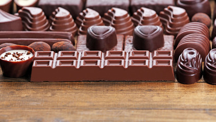 Delicious chocolate candies on wooden background