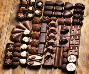 Delicious chocolate candies on wooden background