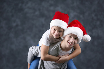 Obraz premium Brothers in Santa hats have fun on grey background