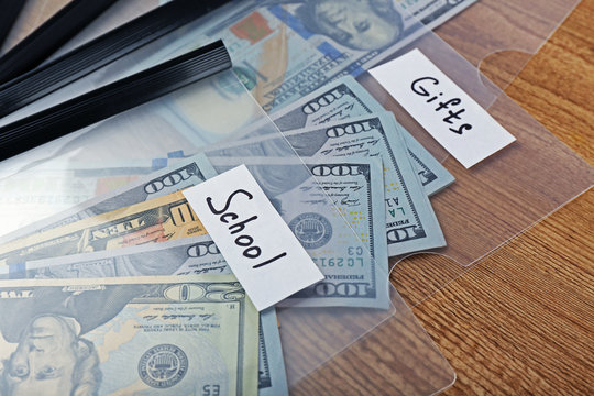 Distribution of money, financial planning, dollars in envelopes, on wooden table background