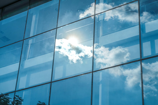 Sun ray and blue sky reflection on window office building, Busin
