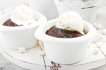 Chocolate lava cake with ice-cream in bowls, on the wooden board