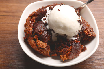 Chocolate lava cake with ice-cream in a bowl, on the wooden table
