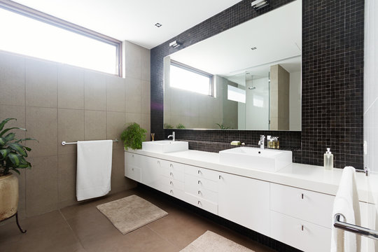 Black mosaic tiled splashback and double basin bathroom