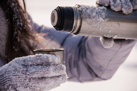 Woman Pours Tea From A Thermos Winter