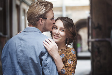 Young couple in love outdoor.  Man hugs  woman. The girl looks over the shoulder of a partner