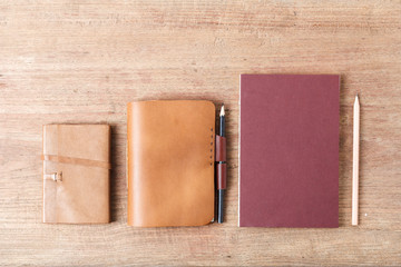 Closed up leather notebooks on wooden background