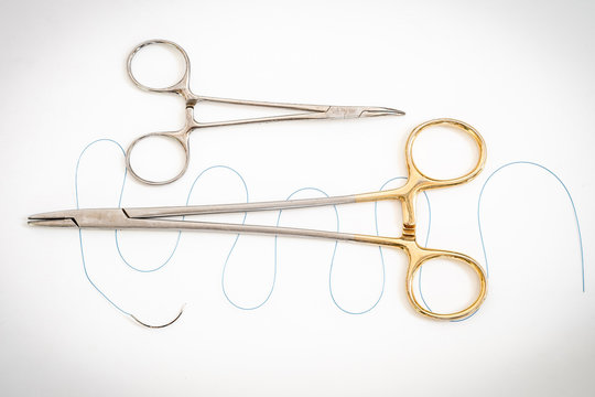 Close up of needle holder with suture and needle