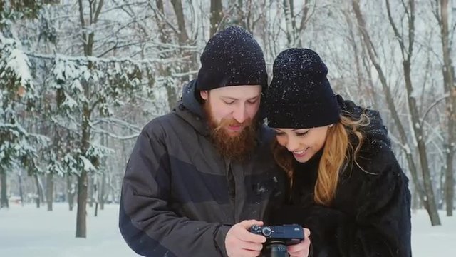 Couple looks pictures on the camera screen