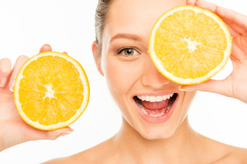 Nice laughing girl with orange slices in front of her eye