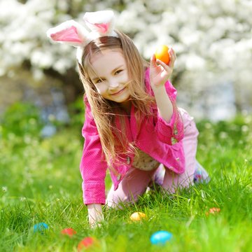Adorable little girl hunting for easter egg on Easter day