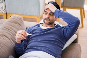 Fototapeta premium Sick man checking his temperature