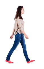 back view of walking  woman in jeans .