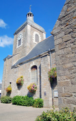 Fototapeta na wymiar Church with flowers against the blue sky in France