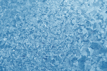 Fototapeta na wymiar Frost patterns on window glass in winter. Frosted Glass Texture. Blue