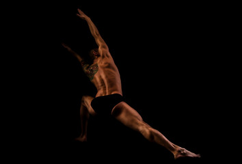 young man doing yoga and gymnastics, lunging leg © lokisurina