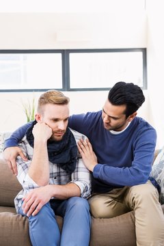 Gay Couple Comforting Each Other On The Couch