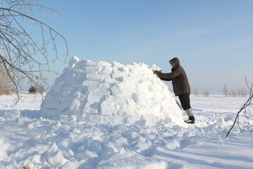 The man  building an igloo on a snow glade in the winter © Nataliia Makarova