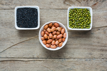 Group of multicolored beans and lentils in melamine cup on woode