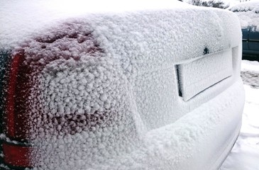Car back trunk covered by a snow during winter season.