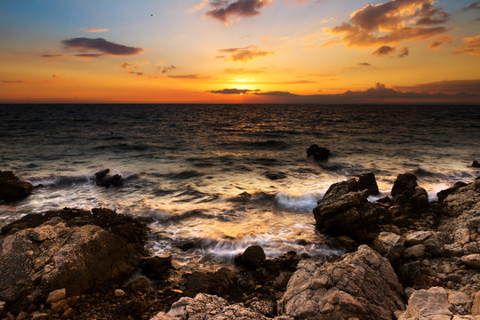 Beautiful colored sunset at the rocky coast of Croatia
