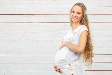 Obraz premium Portrait of the young happy smiling pregnant woman