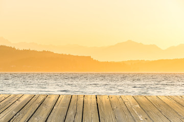 Fototapeta premium empty wooden deck table top Ready for product display montage with sea sunset background.